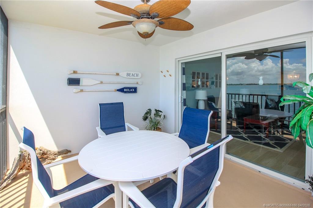 20 Northeast Plantation Road, Unit 205 Jensen Beach, FL 34957 - Photo 11 of 30 a view of a dining room with furniture wooden floor and chandelier