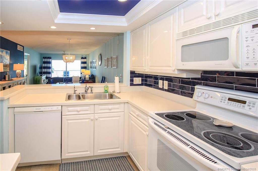 20 Northeast Plantation Road, Unit 205 Jensen Beach, FL 34957 - Photo 14 of 30 a kitchen with a stove a sink and a microwave