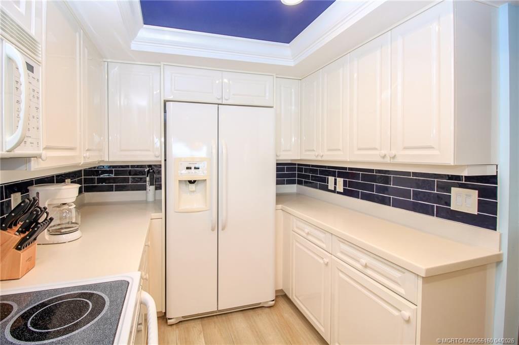 20 Northeast Plantation Road, Unit 205 Jensen Beach, FL 34957 - Photo 16 of 30 a kitchen with a refrigerator and a stove