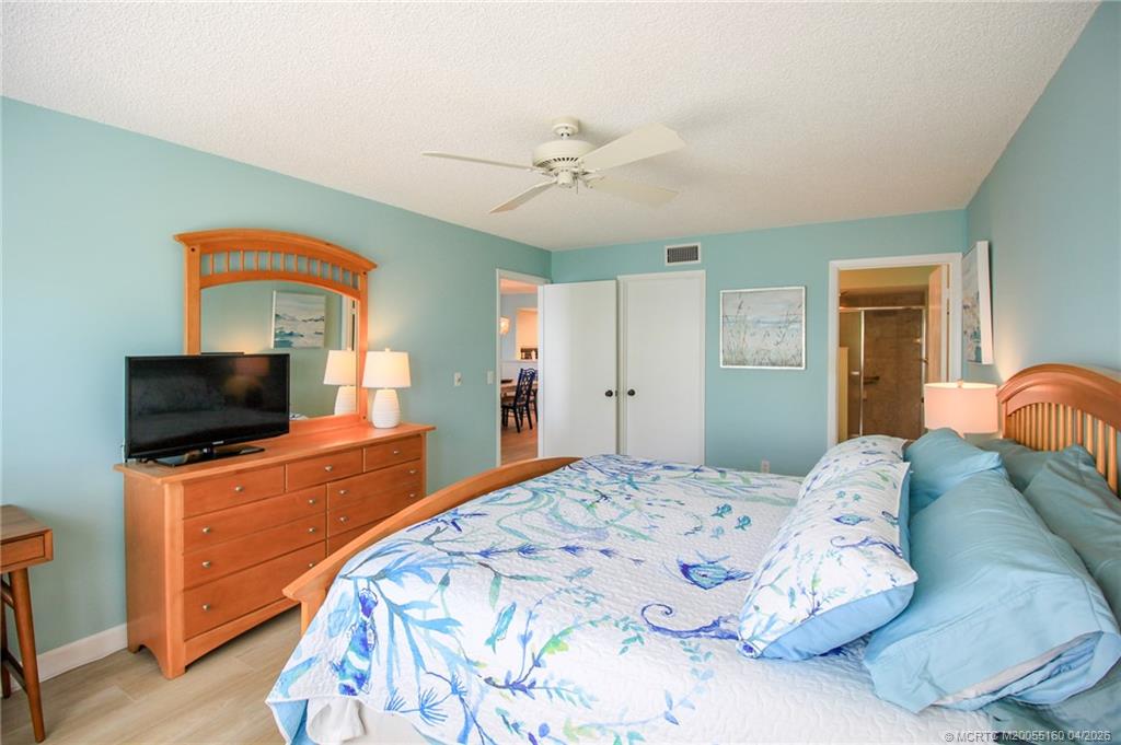 20 Northeast Plantation Road, Unit 205 Jensen Beach, FL 34957 - Photo 18 of 30 a bedroom with a bed and a flat screen tv