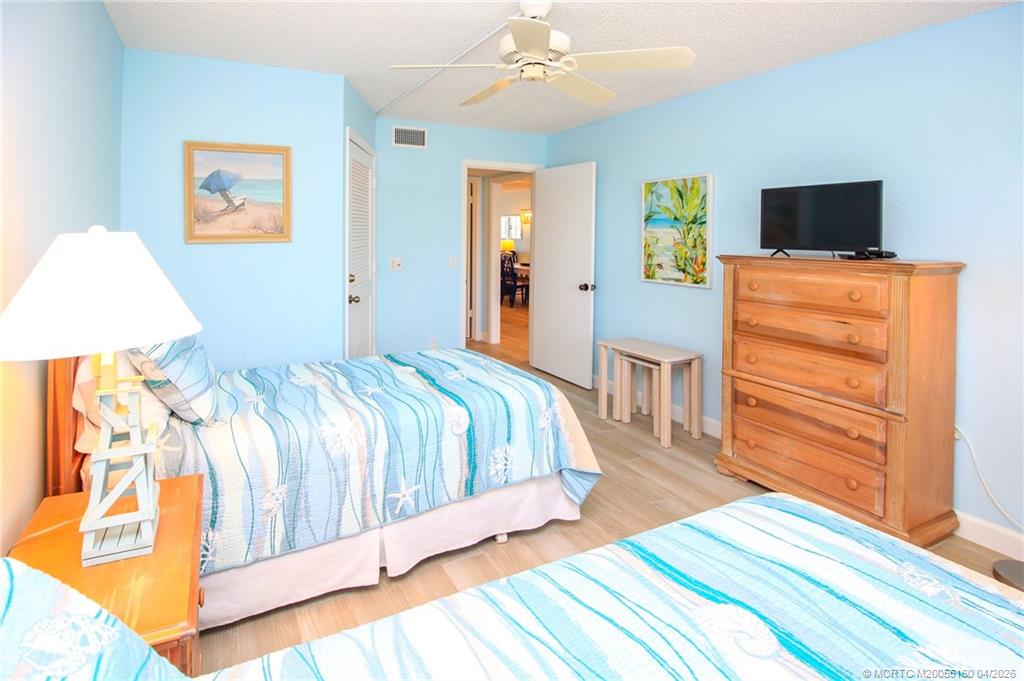 20 Northeast Plantation Road, Unit 205 Jensen Beach, FL 34957 - Photo 22 of 30 a bedroom with a bed and wooden floor