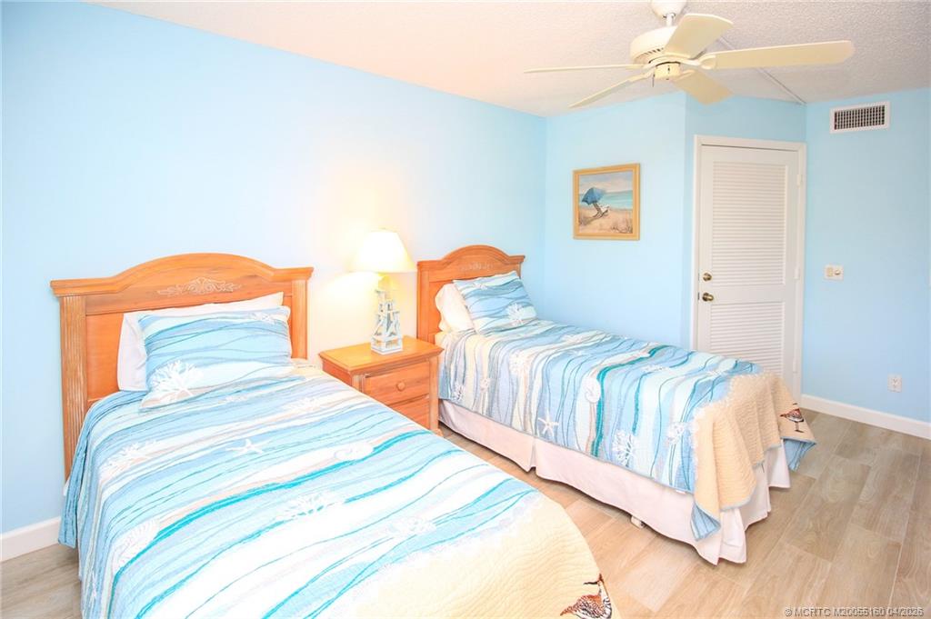 20 Northeast Plantation Road, Unit 205 Jensen Beach, FL 34957 - Photo 23 of 30 a bedroom with two beds and painting on the wall
