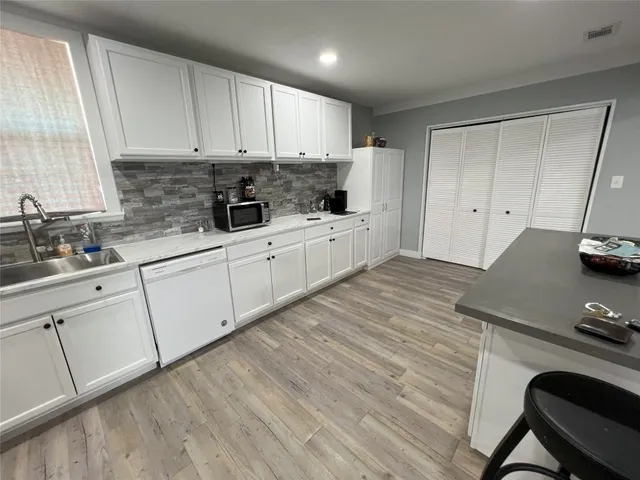 a kitchen with granite countertop white cabinets and white appliances