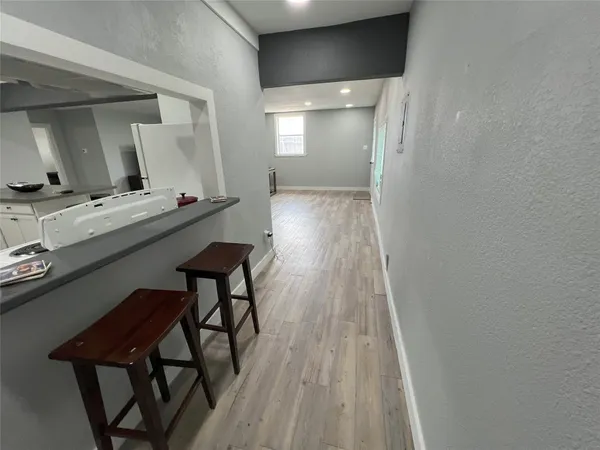 a room with stainless steel appliances wooden floor and chair