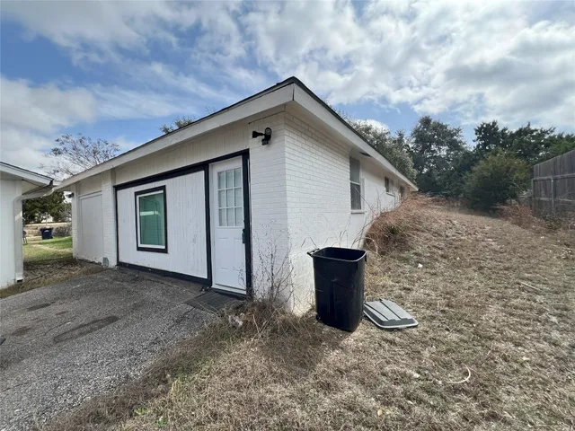 a view of a house with backyard and barbeque grill