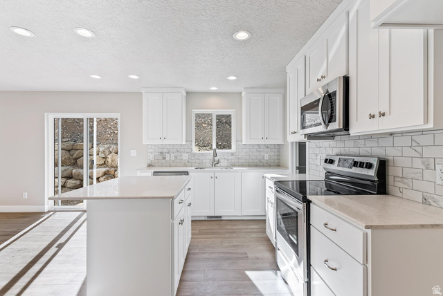 257 North Slant Road, Unit 51M Mapleton, UT 84660 - Photo 5 of 24 Kitchen featuring stainless steel appliances, a kitchen island, recessed lighting, light stone counters, and white cabinetry