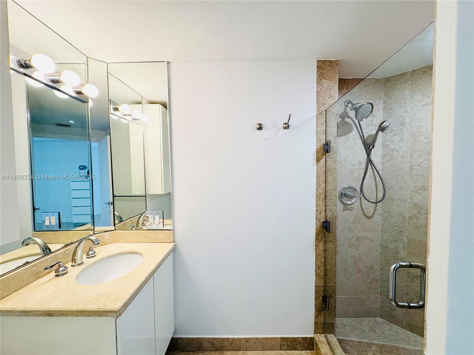 4779 Collins Avenue, Unit 2106 Miami Beach, FL 33140 - Photo 12 of 25 a bathroom with a sink and mirror
