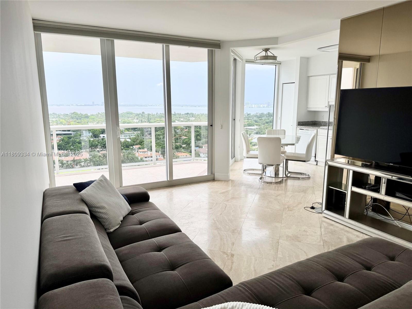 4779 Collins Avenue, Unit 2106 Miami Beach, FL 33140 - Photo 2 of 25 a living room with furniture and a flat screen tv