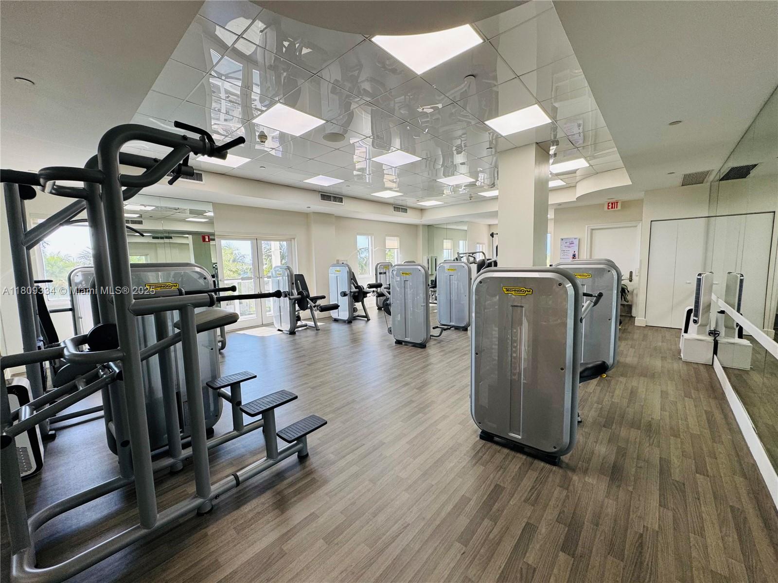 4779 Collins Avenue, Unit 2106 Miami Beach, FL 33140 - Photo 25 of 25 a gym room with lots of gym equipment and wooden floor