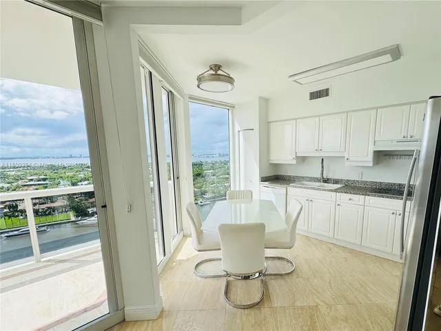 a kitchen with a stove a sink and a view of living room