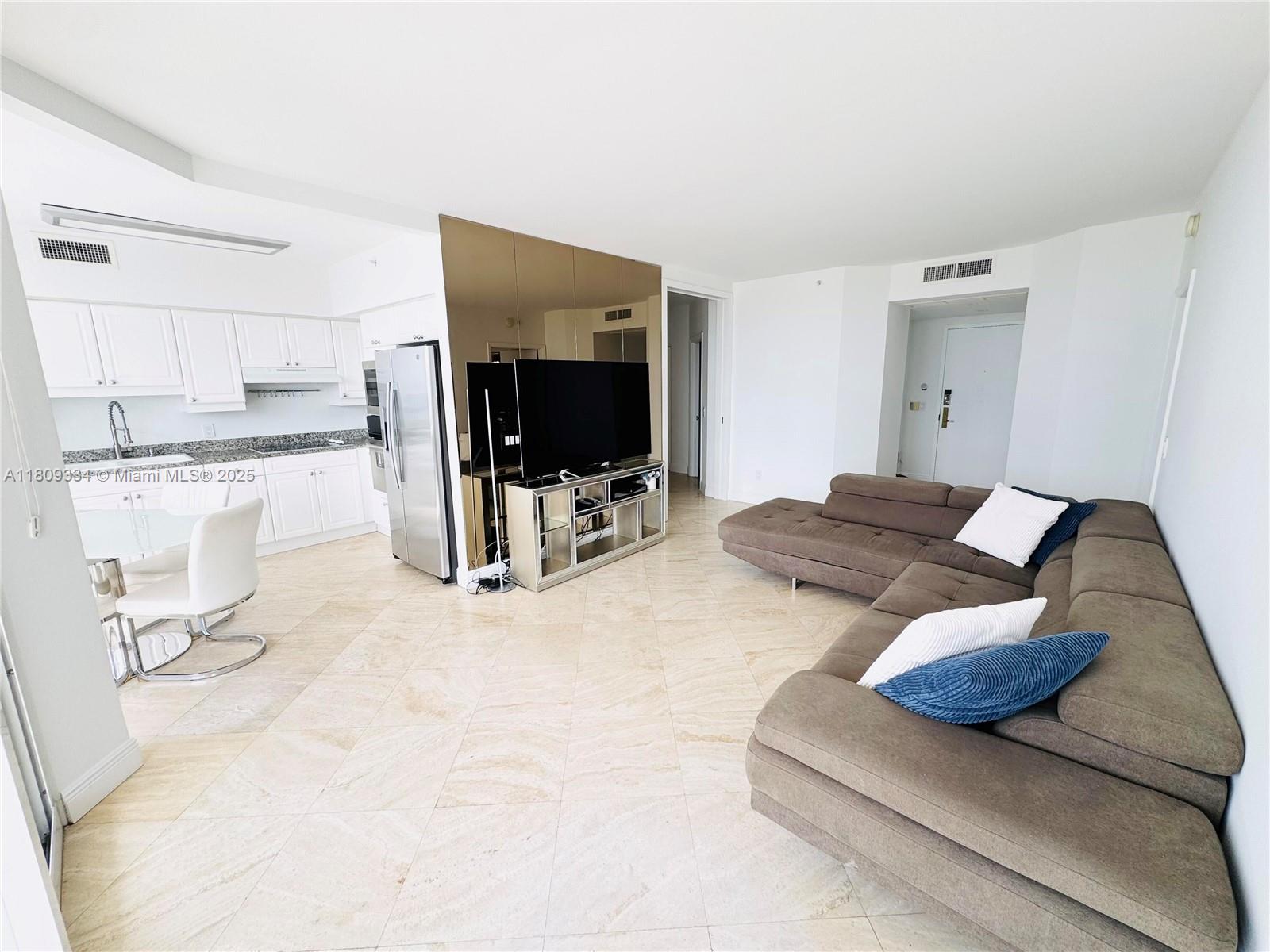 4779 Collins Avenue, Unit 2106 Miami Beach, FL 33140 - Photo 6 of 25 a living room with furniture and a flat screen tv