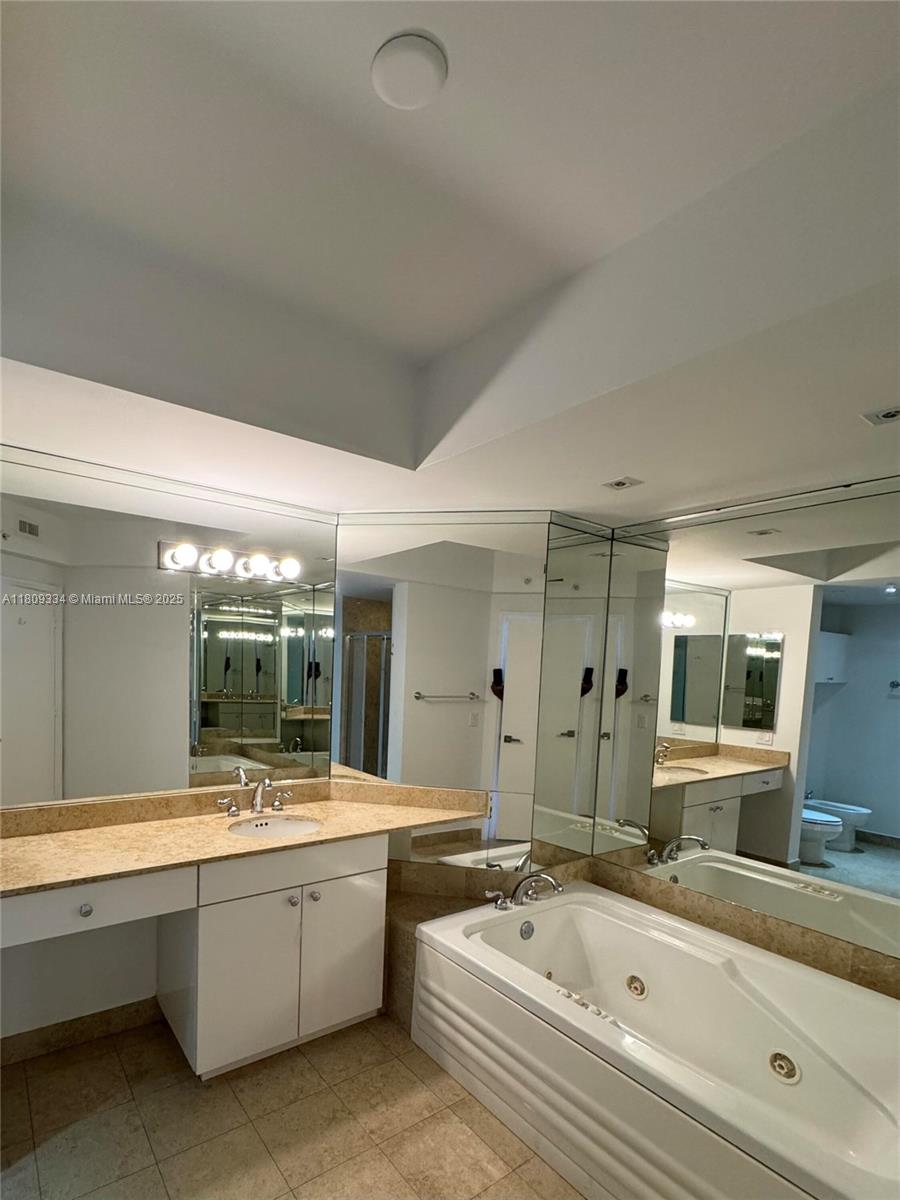 4779 Collins Avenue, Unit 2106 Miami Beach, FL 33140 - Photo 10 of 25 a large bathroom with a double vanity sink mirror and bathtub