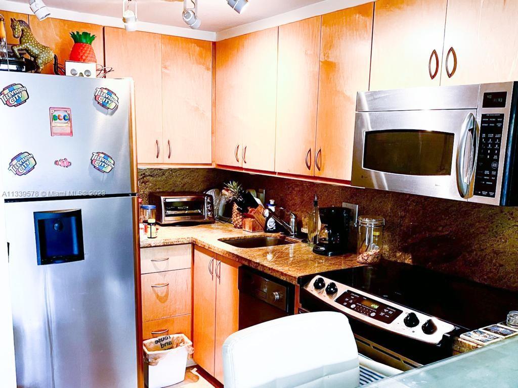 1650 Northeast 115th Street, Unit 102 Miami, FL 33181 - Photo 14 of 35 a kitchen with stainless steel appliances a stove and a refrigerator