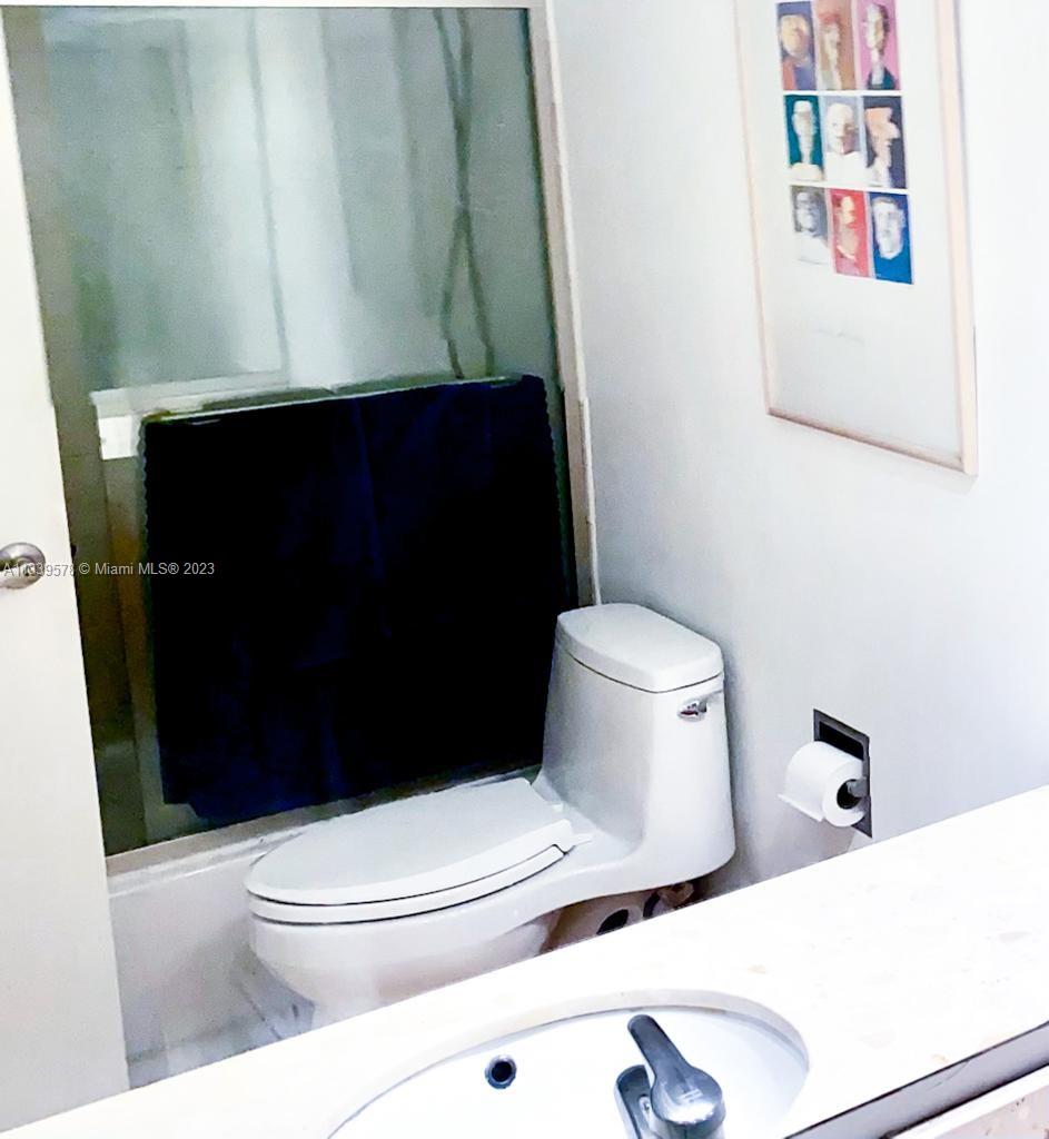 1650 Northeast 115th Street, Unit 102 Miami, FL 33181 - Photo 16 of 35 a bathroom with a toilet and a shower curtain