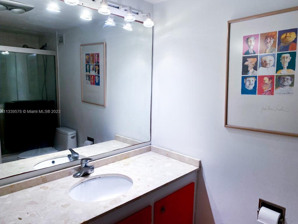 1650 Northeast 115th Street, Unit 102 Miami, FL 33181 - Photo 17 of 35 a bathroom with a sink vanity and a mirror