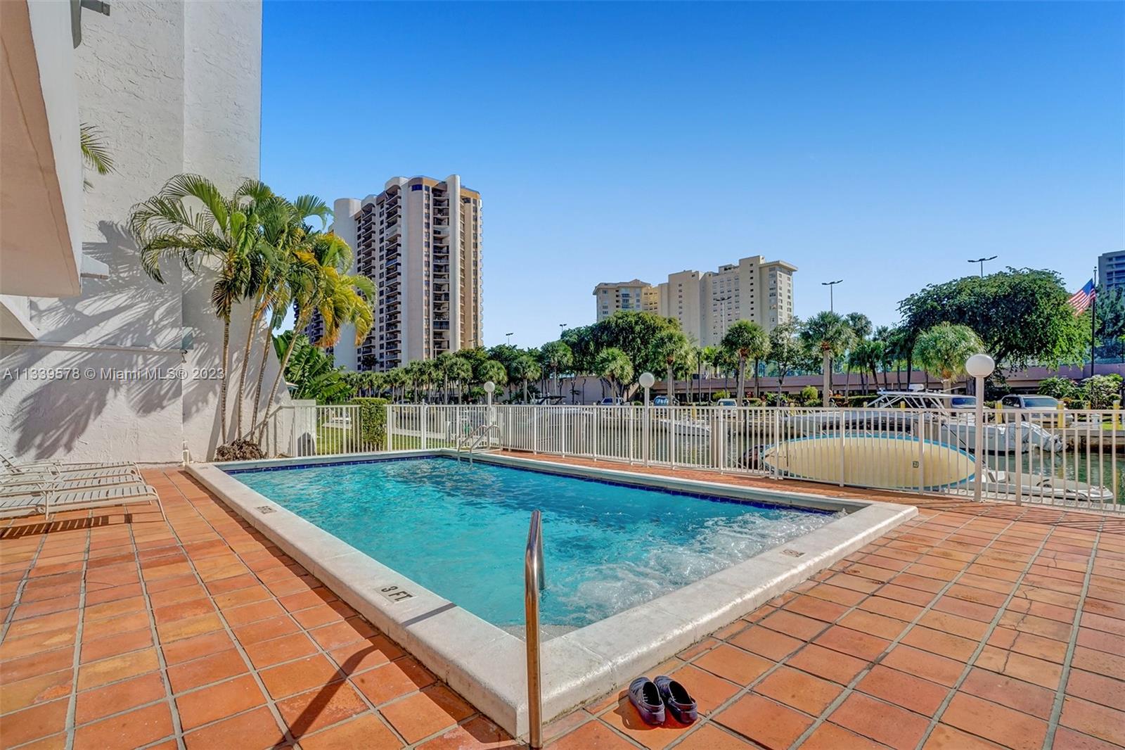 1650 Northeast 115th Street, Unit 102 Miami, FL 33181 - Photo 25 of 35 a swimming pool with outdoor seating and yard