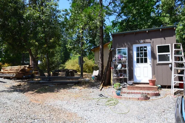 a view of backyard with wooden fence and a bench