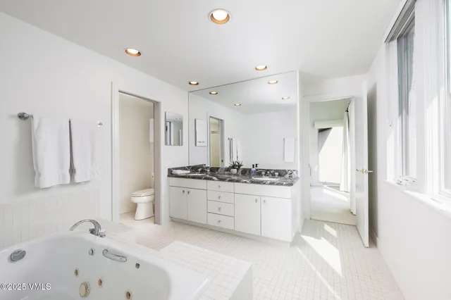 a bathroom with a bathtub sink and mirror