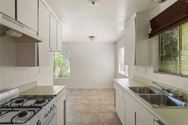 a kitchen with granite countertop a stove and a sink