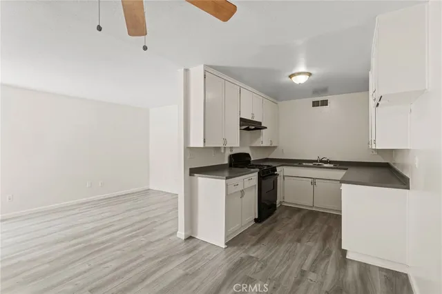 a kitchen with granite countertop white cabinets and white appliances
