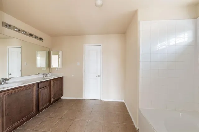 a large bathroom with a double vanity sink and a mirror