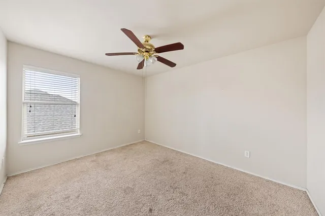 an empty room with a window and a fan