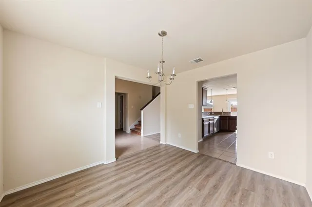 a view of a room with wooden floor staircase and a hallway