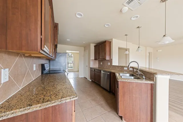 a kitchen with stainless steel appliances granite countertop a sink stove and cabinets