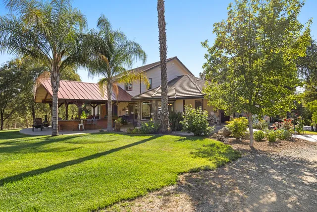 a front view of a house with swimming pool having outdoor seating