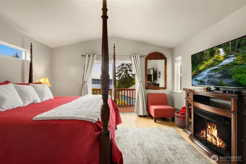 a bedroom with a bed window and a flat tv screen