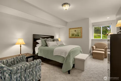 a bedroom with bed couch and window
