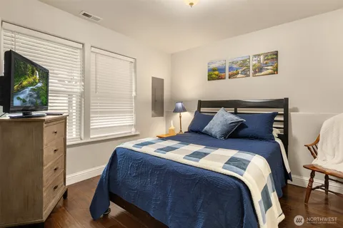 a bedroom with a bed and a flat tv screen on dresser