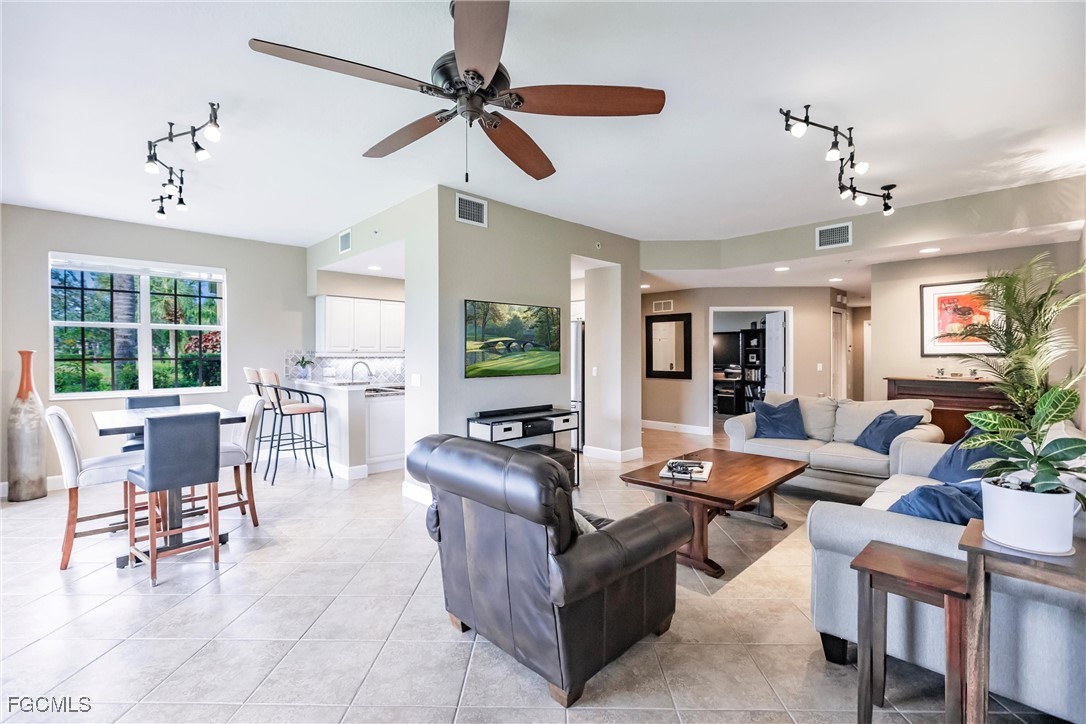 13120 Pebblebrook Point Circle, Unit 102 Fort Myers, FL 33905 - Photo 12 of 50 a living room with furniture a dining table and a large window
