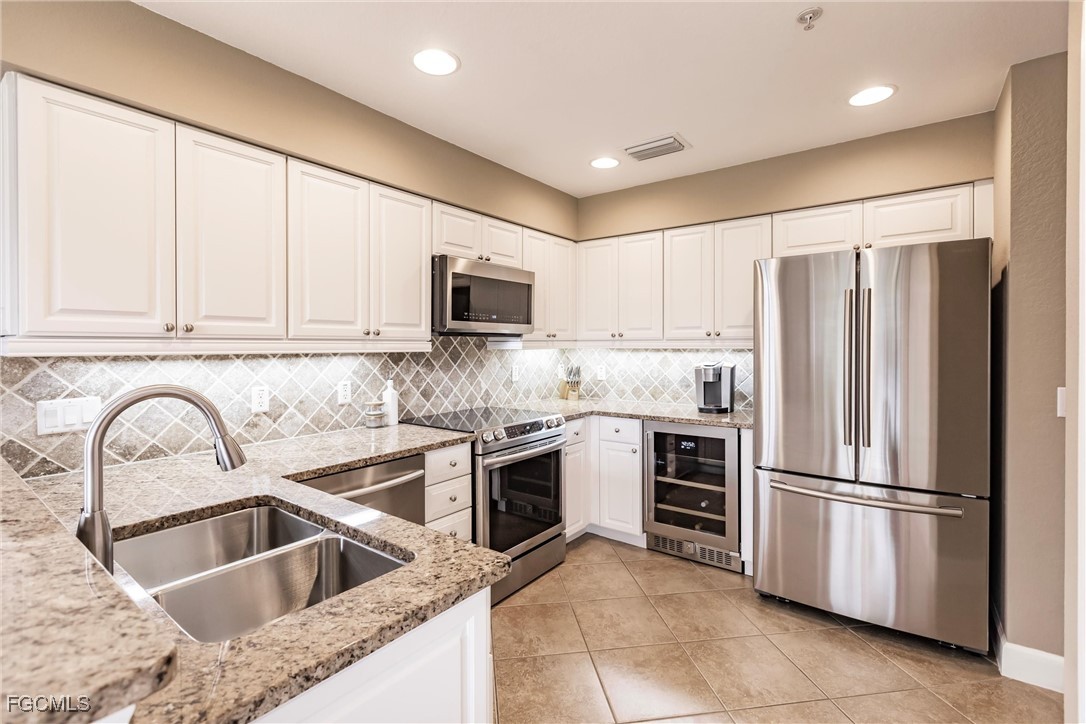 13120 Pebblebrook Point Circle, Unit 102 Fort Myers, FL 33905 - Photo 15 of 50 a kitchen with granite countertop a refrigerator sink and microwave