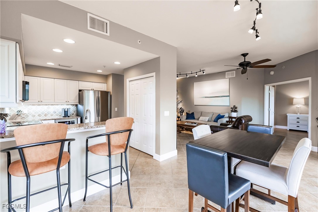 13120 Pebblebrook Point Circle, Unit 102 Fort Myers, FL 33905 - Photo 23 of 50 a kitchen with a dining table chairs and refrigerator