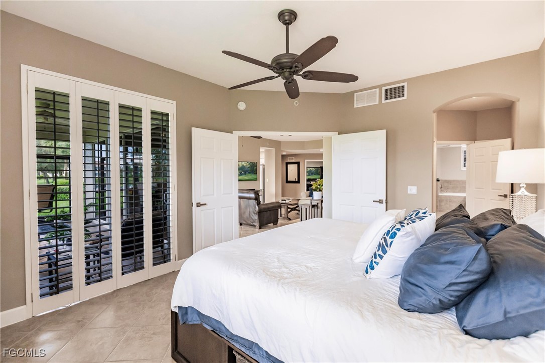 13120 Pebblebrook Point Circle, Unit 102 Fort Myers, FL 33905 - Photo 26 of 50 a spacious bedroom with a large bed and a chandelier