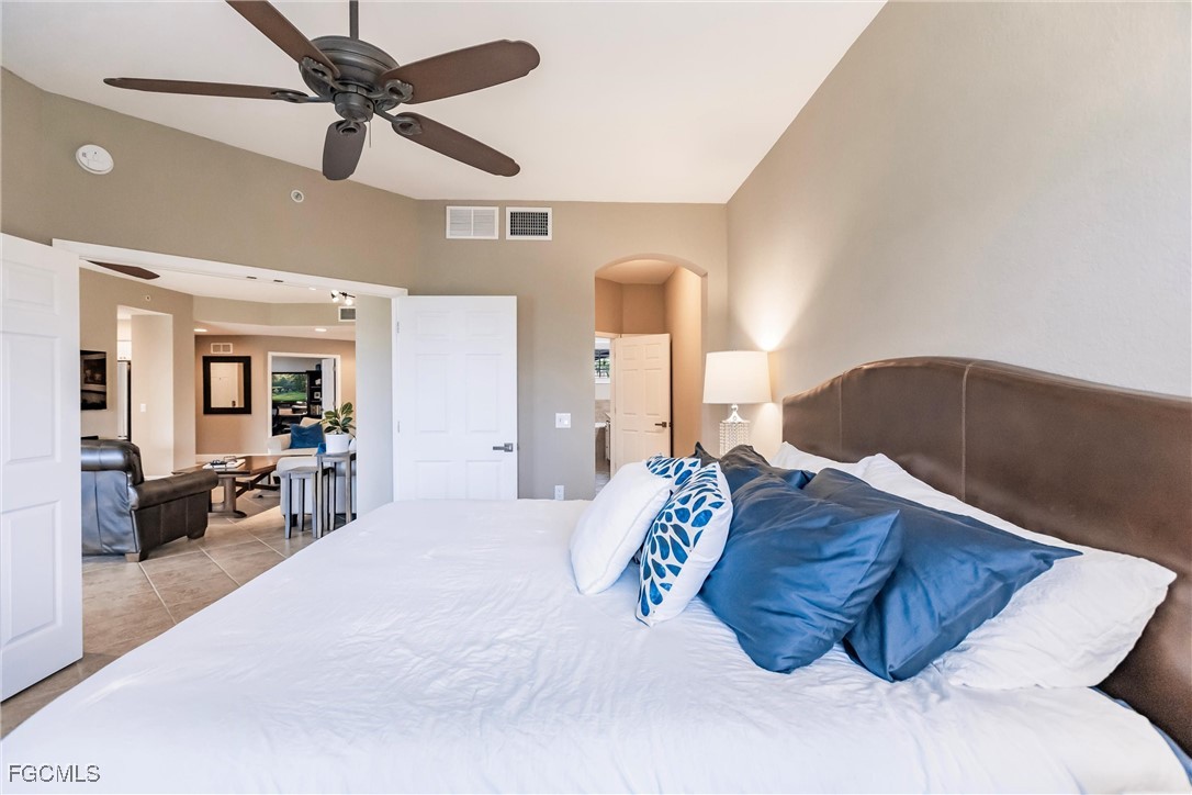13120 Pebblebrook Point Circle, Unit 102 Fort Myers, FL 33905 - Photo 27 of 50 a bedroom with a large bed and a chandelier