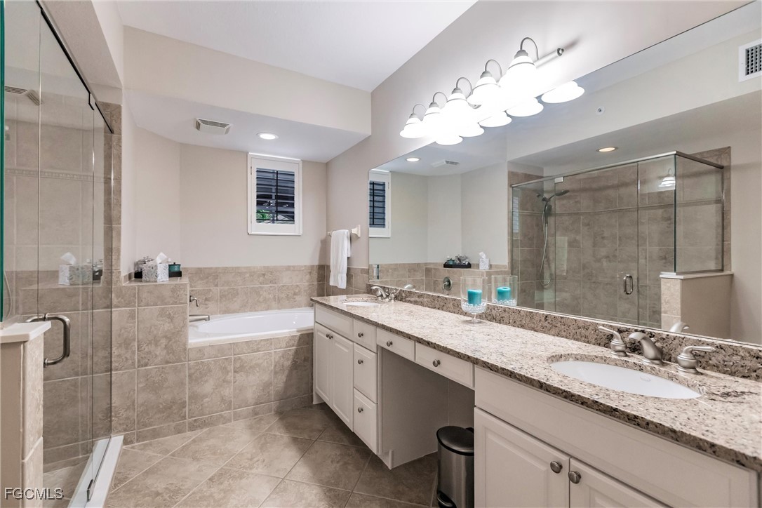 13120 Pebblebrook Point Circle, Unit 102 Fort Myers, FL 33905 - Photo 30 of 50 a bathroom with a granite countertop sink a large mirror and a bathtub