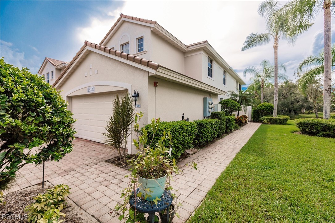 13120 Pebblebrook Point Circle, Unit 102 Fort Myers, FL 33905 - Photo 4 of 50 a view of a white house with a yard and potted plants