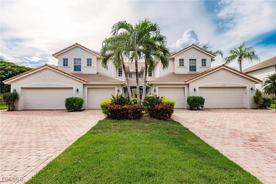 13120 Pebblebrook Point Circle, Unit 102 Fort Myers, FL 33905 - Photo 50 of 50 a front view of a house with a yard and garage