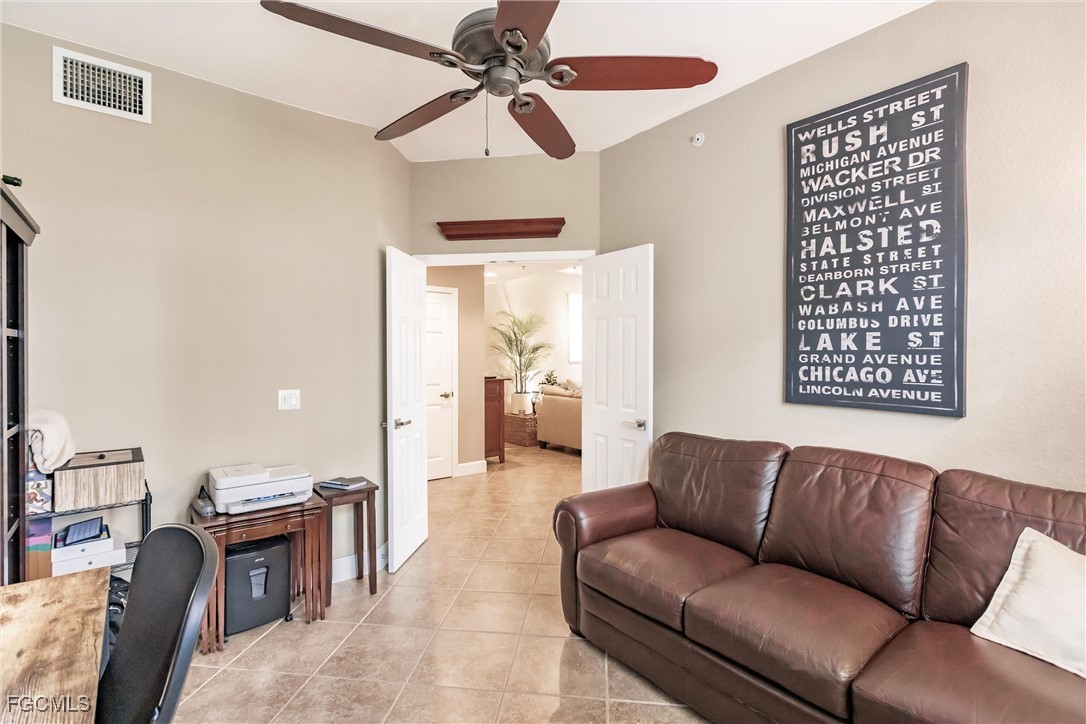 13120 Pebblebrook Point Circle, Unit 102 Fort Myers, FL 33905 - Photo 8 of 50 a living room with furniture a ceiling fan and a rug