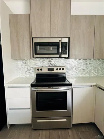 a kitchen with stainless steel appliances granite countertop a stove microwave and oven