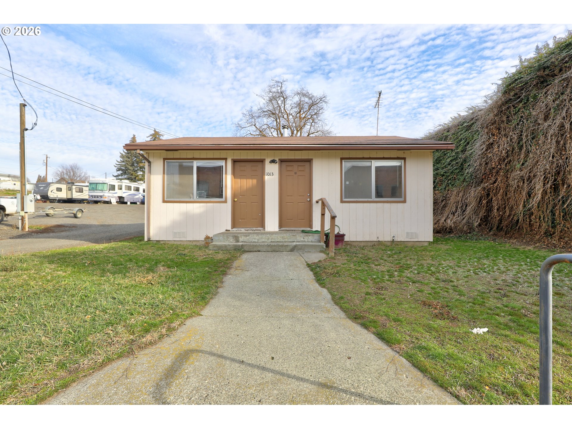 1013 Clark Street Wasco, OR 97065 - Photo 2 of 19 a view of a yard in front of a house with plants and large tree