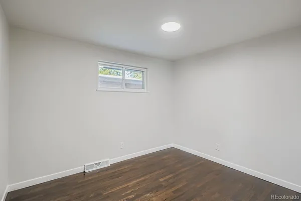 a view of a small space with wooden floor and a window