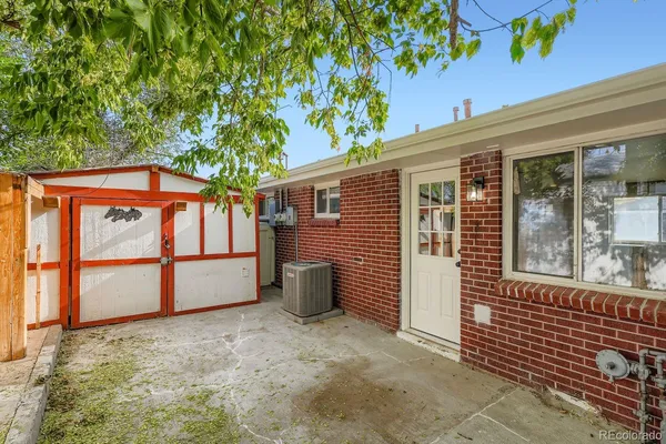 a backyard of a house with barbeque oven and outdoor seating