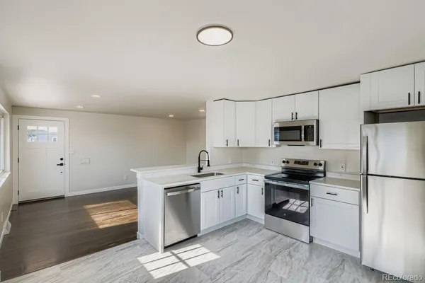 a kitchen with a stove a sink and a refrigerator