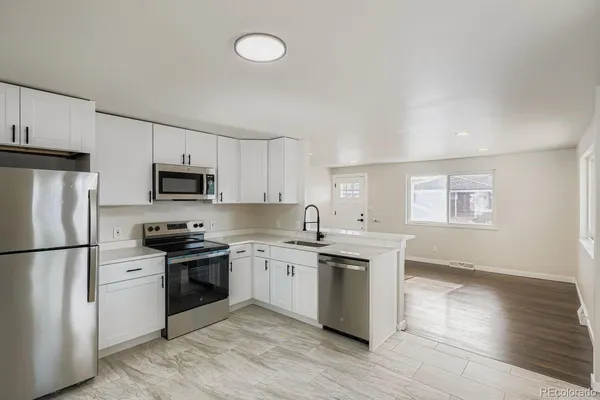 a kitchen with stainless steel appliances a sink stove and refrigerator