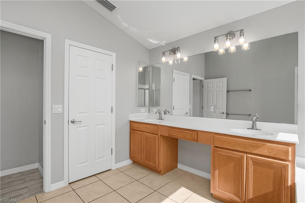 2022 Fairmont Lane Naples, FL 34120 - Photo 12 of 33 a large bathroom with a double vanity sink a large mirror and a shower
