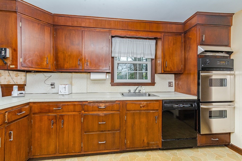 50 Oak Ridge Road Reading, MA 01867 - Photo 5 of 36 a kitchen with stainless steel appliances granite countertop wooden cabinets a stove top oven a sink and dishwasher