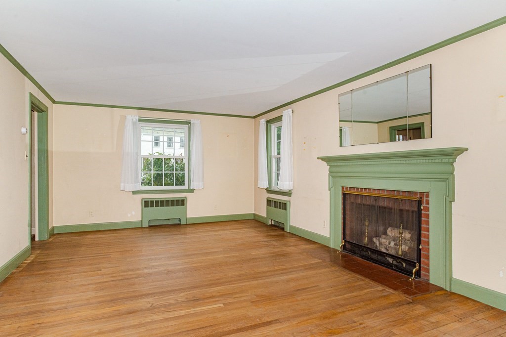 50 Oak Ridge Road Reading, MA 01867 - Photo 7 of 36 a view of an empty room with wooden floor fireplace and a window